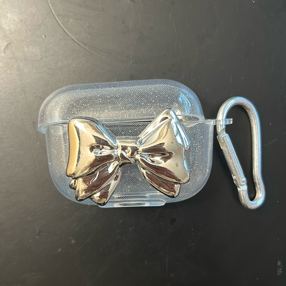 Clear sparkly AirPod pro case with silver bow in the front.